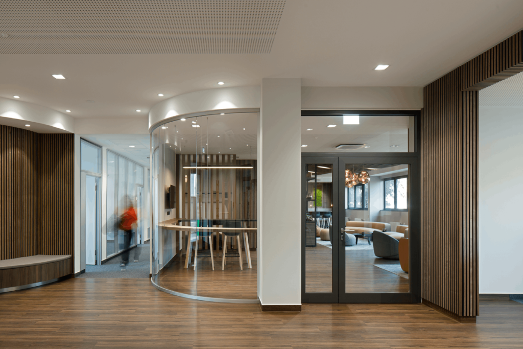 Runde Glasscheibe öffnet den Blick in den kommunikativen Loungebereich